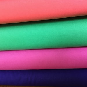 May include: Four rolls of fabric in different colors: coral, green, pink, and purple.