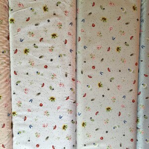 May include: Four fabric swatches with a white background and a repeating pattern of small flowers, leaves, and other botanical elements. The swatches are in shades of beige, light blue, and gray.