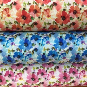 May include: Three rolls of fabric with different floral patterns. The top roll has a red and pink floral pattern, the middle roll has a blue floral pattern, and the bottom roll has a pink floral pattern.
