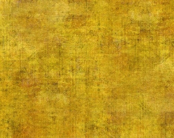 May include: A piece of fabric featuring a mottled, distressed texture in shades of golden yellow, mustard, and deep brown. A white ruler with black markings is visible along the top edge, measuring approximately 12 inches in total length.