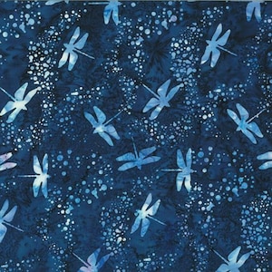 May include: Dark blue fabric with a repeating pattern of light blue dragonflies and white speckles. The dragonflies are stylized with detailed wings, creating a whimsical and nature-inspired design. The fabric has a batik-like appearance.