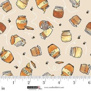 May include: Fabric with a repeating pattern of honey jars and bees on a beige background. The jars are various sizes and shapes, with the word "HONEY" or "HUNNY" printed on them. The design includes a ruler in inches.