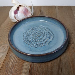 Assiette en céramique pour râper l'ail ou le gingembre, servant également de repose-cuillère ou de coupelle pour tremper le pain dans l'huile d'ail. Céramique artisanale blanche, bleue, verte ou turquoise.