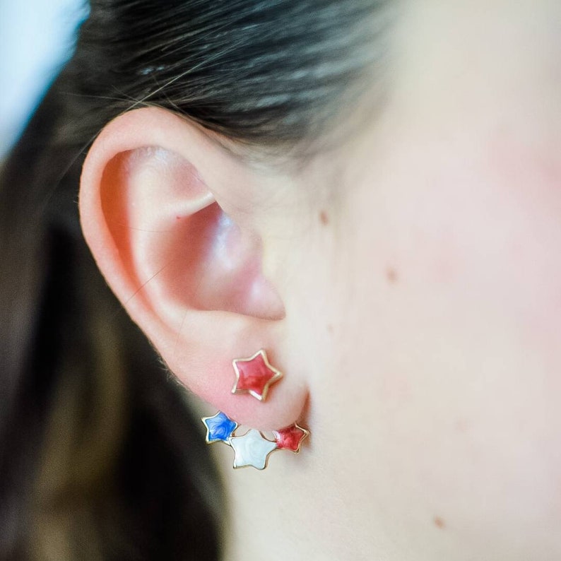 Close-up on model wearing patriotic red, white, and blue star earrings, ideal accessory for Independence Day celebrations.