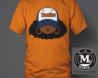 May include: Orange t-shirt with a graphic of a woman wearing a blue and white baseball cap with the text "Morgan State" on it. The graphic also includes a black afro and large gold hoop earrings. The t-shirt has the text "Rep My School" in a circle with a large "M" in the center.