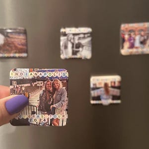 May include: A square magnet with a photo of two women standing in front of a building. The magnet has the text "INDIANAPOLIS" and "ERAS TOUR 2024" on it.