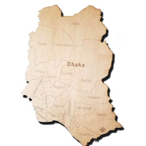 May include: A wooden map of Dhaka, Bangladesh, showing the different neighborhoods of the city. The map is light brown in color and has a compass rose in the lower right corner.
