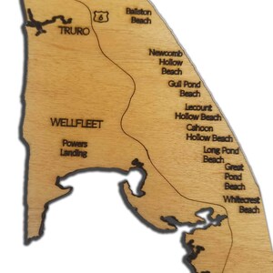 May include: A wooden map of Cape Cod, Massachusetts, with the names of various beaches and towns, including Truro, Wellfleet, Ballston Beach, Newcomb Hollow Beach, Gull Pond Beach, Lecount Hollow Beach, Cahoon Hollow Beach, Long Pond Beach, Great Pond Beach, and Whitecrest Beach.