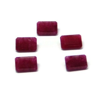 Puede incluir: Seis piedras preciosas rectangulares de color rosa oscuro con una superficie ligeramente texturizada.