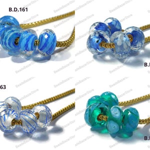 May include: Four sets of glass beads on a gold chain. The beads are blue and white with a swirl pattern, blue with white dots, clear with blue swirls, and green with blue swirls.