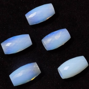 May include: Six oval-shaped, light blue, opaque gemstone beads. The beads are smooth and polished.