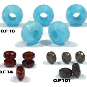 Könnte beinhalten: Sortiment an facettierten Glasperlen in verschiedenen Farben, darunter hellblau, dunkelrot und grau. Die Perlen sind in Gruppen von drei oder vier angeordnet, wobei der Text "O.F.16", "O.F.14" und "O.F.101" unter jeder Gruppe gedruckt ist.