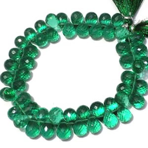 Op de afbeelding: Een streng met facetgeslepen groene edelsteen kralen. De kralen zijn rond en hebben een facetgeslepen afwerking. De kralen zijn geregen op een doorzichtige draad en zijn klaar om te gebruiken voor het maken van sieraden.