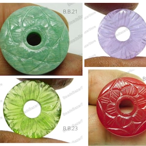 以下が含まれることがあります： 花柄の彫刻が施された宝石のペンダントが4つ。ペンダントは緑、紫、緑、赤。ペンダントにはB.B.21、B.B.22、B.B.23、B.B.24のラベルが貼られています。