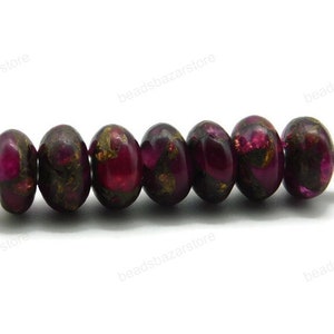 May include: A strand of eight round, dark purple beads with gold flecks. The beads are strung on a silver wire.