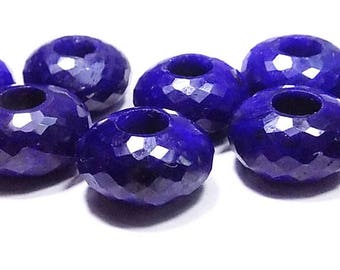 May include: A collection of deep blue, faceted gemstone beads. Each bead has a cylindrical shape with a central hole, and a surface cut with numerous facets. The beads are arranged on a white background, showcasing their color and texture.