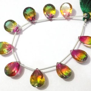 May include: A strand of iridescent gemstone beads in a teardrop shape. The beads are strung on a silver wire and have a rainbow of colors, including pink, green, yellow, and orange.
