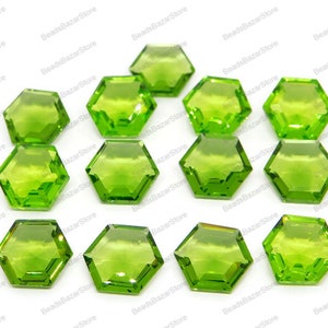 May include: A collection of 15 green gemstone hexagon beads. The beads are faceted and have a translucent appearance.