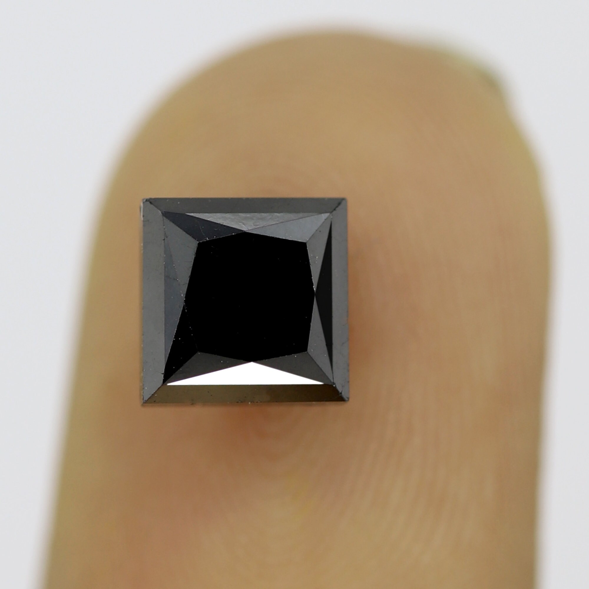 Princess cut black diamond on finger