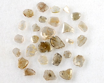May include: A collection of rough, unpolished, brown diamonds. The diamonds are various shapes and sizes.