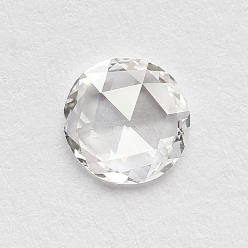 K&ouml;nnte beinhalten: Ein klarer, runder, facettierter Diamant-Edelstein mit Brillantschliff.