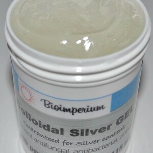 May include: A white plastic jar with a blue and white label that reads "Bioimperium Colloidal Silver Gel Guaranteed for Silver content ent antifungal, antibacterial ant Ppm - 4 ounces - 118". The jar is filled with a clear, viscous liquid.