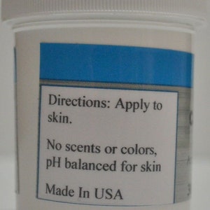 May include: White plastic jar with a blue label. The label says "Directions: Apply to skin. No scents or colors, pH balanced for skin. Made in USA."