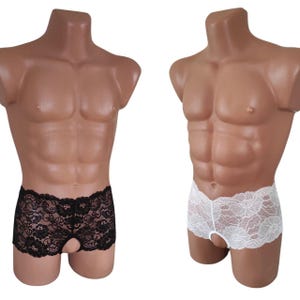 Puede incluir: Dos pares de ropa interior de encaje, uno negro y otro blanco, exhibidos en maniquíes. La ropa interior presenta un patrón floral de encaje y un diseño de ojo de cerradura en la parte delantera. Los maniquíes son de color bronceado.