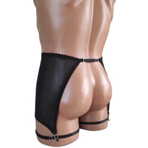 May include: Black lingerie with a sheer, scalloped-edge skirt and adjustable garter straps. The garment features a delicate, see-through design and a small, adjustable back strap. The lingerie is displayed on a mannequin.
