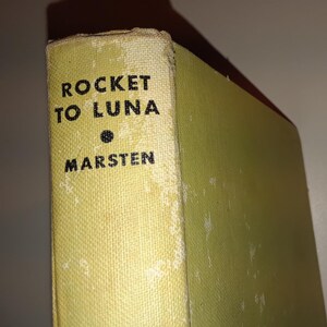 May include: A vintage paperback book with a yellow cover and black text that reads "ROCKET TO LUNA" and "MARSTEN".