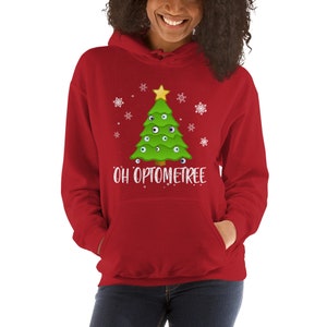 May include: Red hooded sweatshirt with a white Christmas tree design. The tree is decorated with green and white eyes and a yellow star. The text "OH OPTOMETREE" is printed below the tree.