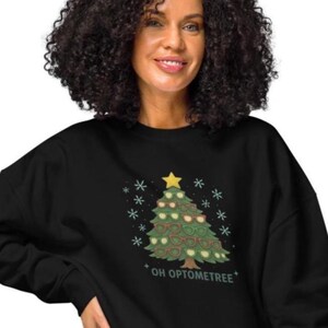 May include: Black sweatshirt with a Christmas tree design made of eyeglasses. The tree is decorated with eyeglasses and topped with a gold star. The text "OH OPTOMETREE" is below the tree.