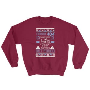 May include: A maroon sweatshirt with a Christmas-themed design. The design features a robot with a Christmas tree on its head and the text "ERROR 404 CHRISTMAS SWEATER NOT FOUND".