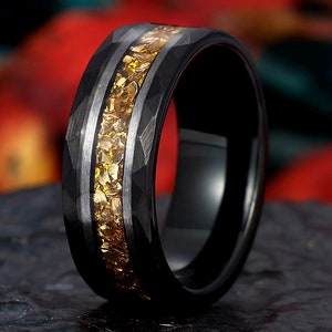 Op de afbeelding: Een zwarte ring van wolfraamcarbide met een band van gele zirkonia-stenen.