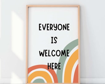 May include: A framed print with a white background and the text "Everyone is welcome here" in black. The background features a colorful rainbow design with orange, yellow, and green hues.