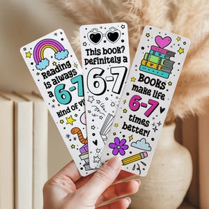May include: Three white bookmarks with colorful illustrations and text. One bookmark reads "Reading is always a 6-7 kind of vibe" with a rainbow. Another says "This book? Definitely a 6-7". The third says "Books make life 6-7 times better!"