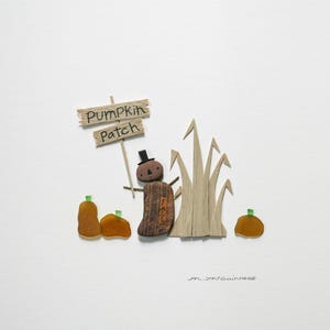 May include: A whimsical sea glass art piece depicting a scarecrow with a sign that reads "Pumpkin Patch". The scarecrow is made of wood and has a black top hat. There are three orange pumpkins and a patch of brown grass.