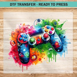 May include: A colorful, abstract design of a video game controller with splashes of paint in shades of blue, green, red, yellow, and orange. The controller is a dark gray color with black buttons and a white background.
