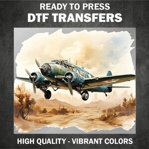 May include: A vintage airplane with a green and blue paint scheme flies over a desert landscape. The airplane has a red, white, and blue star on the tail. "READY TO PRESS DTF TRANSFERS HIGH QUALITY - VIBRANT COLORS" is written on the image.