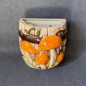 May include: A set of three ceramic mugs with a speckled, matte finish. Each mug features a different color: light blue, cream, and gray. The mugs have a simple, modern design with a rounded shape and a comfortable handle.