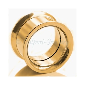 Peut inclure: Un bijou de piercing d'oreille de style tunnel de couleur or. Le bijou est cylindrique avec une surface lisse et polie. Le design présente un bord évasé des deux côtés, créant un look élégant et moderne. Conçu pour les piercings d'oreille étirés.