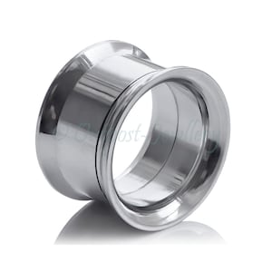 Peut inclure: Un écarteur d'oreille argenté brillant, également appelé plug, de forme évasée. Le bijou en métal poli reflète la lumière, créant un aspect lumineux. Le plug est conçu pour être inséré dans un piercing d'oreille élargi. Diamètre: environ 1,5 cm.