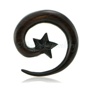 Può includere: Spirale per orecchio in legno marrone scuro con un design a stella intagliata. La spirale si curva, creando una forma unica. Questo gioiello per il corpo è progettato per piercing all'orecchio allargati.