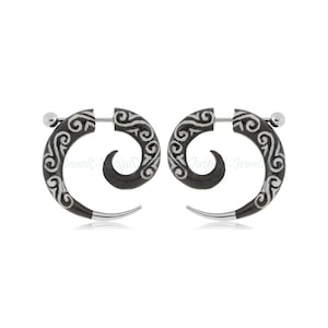 May include: A pair of black spiral earrings with a silver-colored accent at the tip and a white, swirling design. The earrings have a post and ball closure. The earrings are displayed against a white background.