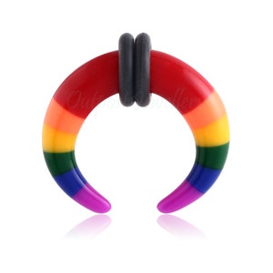 May include: A rainbow-colored, curved ear gauge with a dark gray center ring. The gauge transitions from red to orange, yellow, green, blue, and purple. The jewelry is designed to stretch the earlobe.