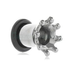 May include: A silver-colored crown-shaped ear gauge with a black rubber O-ring. The gauge has a polished finish and a hollow center. The crown design features rounded tips.