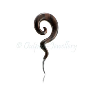 Könnte beinhalten: Ein dunkelbrauner Ohrschmuck aus Holz in Spiralform mit einer silberfarbenen, spitzen Spitze. Der Schmuck hat eine glatte, polierte Oberfläche und ein geschwungenes Design. Der Text "© Outpost-Jewellery" ist im Bild zu sehen.