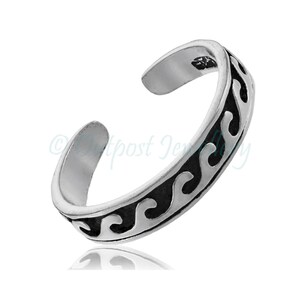 May include: A silver toe ring with a wave pattern design. The adjustable ring features a curved band with a black wave pattern along the outer edge. The ring is shown on a white background.