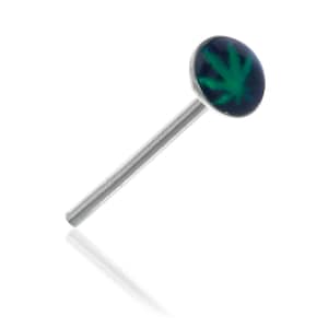 May include: A silver nose stud with a round, dark blue top featuring a green cannabis leaf design. The stud is angled, showing the slender, straight post. The background is white.