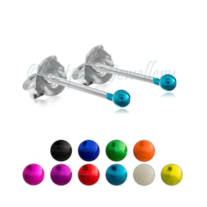 May include: A pair of silver stud earrings with a small, turquoise-colored ball at the end of each post. The image also shows a selection of stud earrings in various colors, including black, blue, green, orange, pink, purple, red, and yellow.